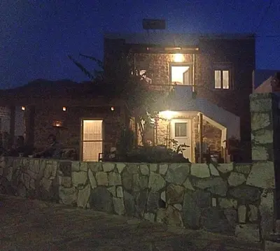 a house at night with a stone wall at Spiros Apartments in Livadia