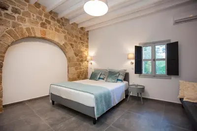 a bedroom with a bed and a brick wall at The Old Town House in Rhodes Town