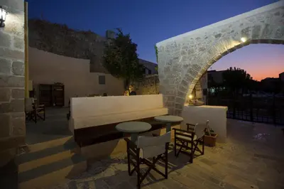 a patio with a table and chairs and a bench at The Old Town House in Rhodes Town