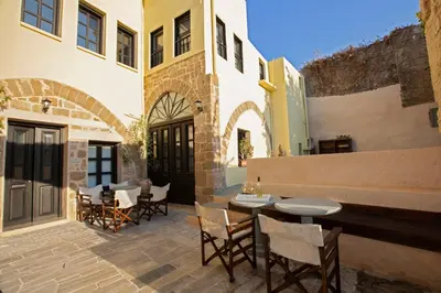 a patio with tables and chairs in a building at The Old Town House in Rhodes Town
