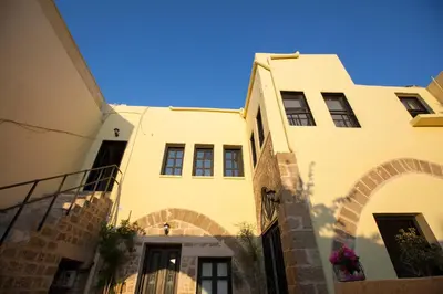 a yellow building with an archway in front of it at The Old Town House in Rhodes Town