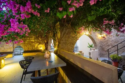 a table and chairs in a room with pink flowers at The Old Town House in Rhodes Town