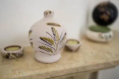 a white vase sitting on a counter with other vases at The Corner House at Gennadi Court in Gennadi