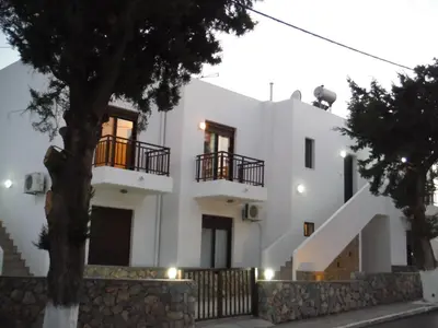 a white house with two balconies and a tree at The Corner House at Gennadi Court in Gennadi