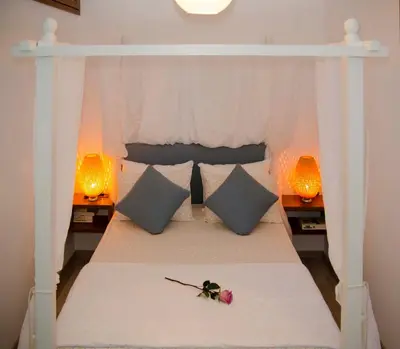 a bed with a white canopy bed with a flower on it at Lindos SeaSide Junior Apartment in Líndos