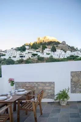 a dining room with a table and a view of a city at Lindos SeaSide Junior Apartment in Líndos
