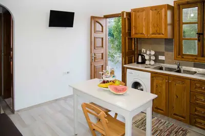 a kitchen with a table with a bowl of fruit on it at Lindos SeaSide Junior Apartment in Líndos