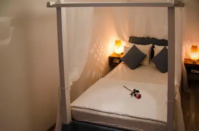 a bedroom with a canopy bed with a flower on it at Lindos SeaSide Junior Apartment in Líndos