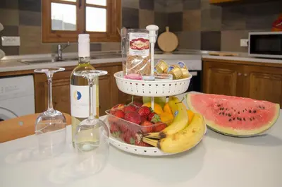 a bottle of wine and a bowl of fruit on a counter at Lindos SeaSide Junior Apartment in Líndos