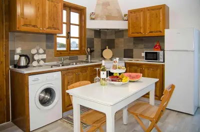 a kitchen with a table with a bowl of fruit on it at Lindos SeaSide Junior Apartment in Líndos