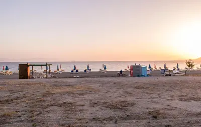 a beach with a bunch of chairs and the ocean at Carpe Diem Studios in Ialyssos