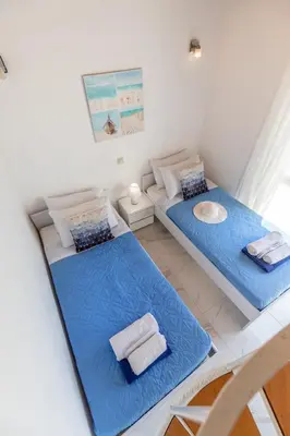 two beds in a small room with blue sheets at White Blue Villa in Lachania