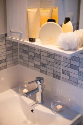 a bathroom sink with candles on a shelf at White Blue Villa in Lachania