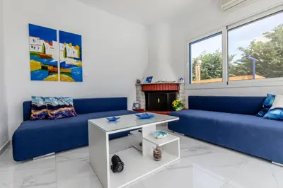 a living room with two blue couches and a fireplace at White Blue Villa in Lachania