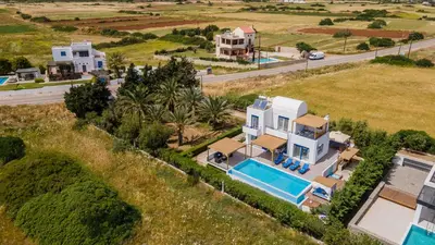 an aerial view of a house with a swimming pool at White Blue Villa in Lachania