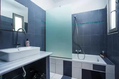 a blue tiled bathroom with a sink and a shower at Rhodes Sea Villas in Ixia