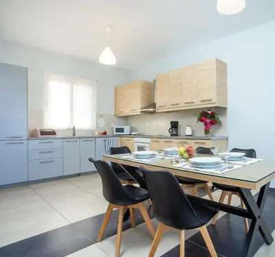 a kitchen with a table and chairs in a room at Rhodes Sea Villas in Ixia
