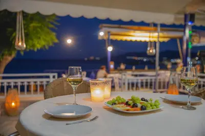 a table with two glasses of wine and a plate of food at St Peter & Paul at haraki in Haraki