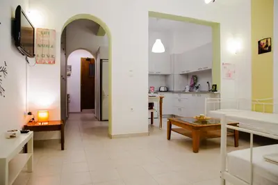 a living room with a table and a kitchen at St Peter & Paul at haraki in Haraki