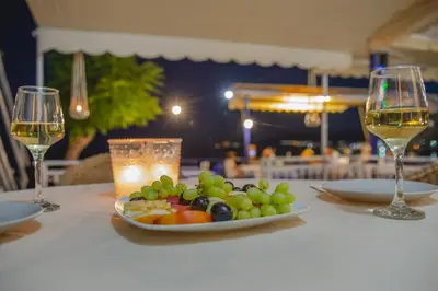 a plate of fruit on a table with wine glasses at St Peter & Paul at haraki in Haraki