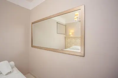 a mirror hanging on a wall in a bathroom at Voula Studios in Faliraki