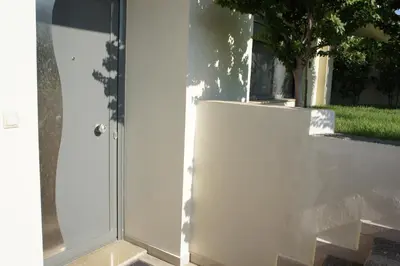 a white wall next to a glass door at Ixia Beach in Ialyssos