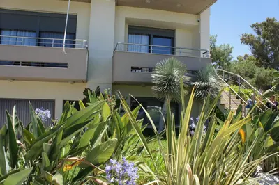 a building with a balcony and some plants at Ixia Beach in Ialyssos