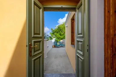 an open door to a hallway with an alley at Over The Sea Apartments in Symi