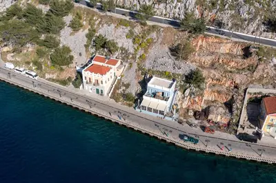 an aerial view of a house next to the water at Over The Sea Apartments in Symi
