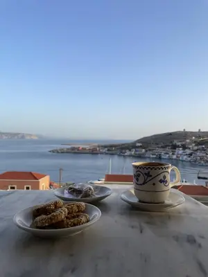 a table with two plates of food and a cup of coffee at Marina Castellana Studios in Halki