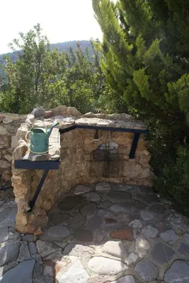 a stone wall with a bird feeder on a table at O Ioannis in Kritinía