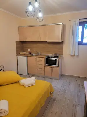 a kitchen with a yellow bed in a room at Kleanthi and Kostas Studios in Symi