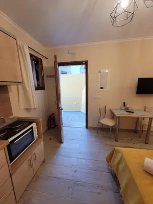 a room with a kitchen and a table and a door at Kleanthi and Kostas Studios in Symi