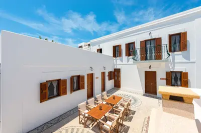 an outdoor patio with a wooden table and chairs at Villa Eftihia in Lindos in Líndos