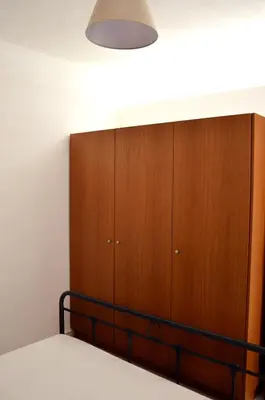 a bedroom with a bed and a wooden cabinet at Sky-Line Apartments in Afantou