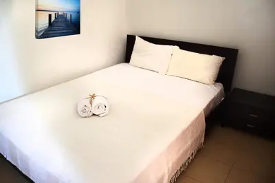 a bedroom with a white bed with two towels on it at Sky-Line Apartments in Afantou