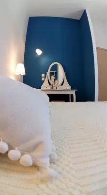 a bedroom with a white bed and a mirror at Villa Miranda in Halki