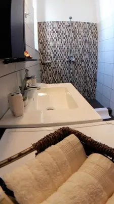 a bathroom with a sink and a tub with a towel at Villa Miranda in Halki