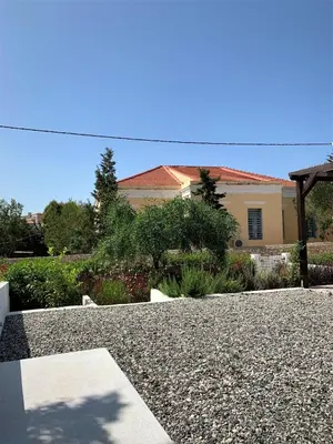 a house with a gravel driveway in front of a house at Villa Miranda in Halki