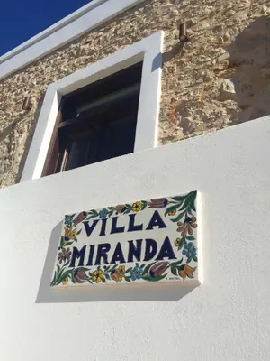 a sign on the side of a building with a window at Villa Miranda in Halki