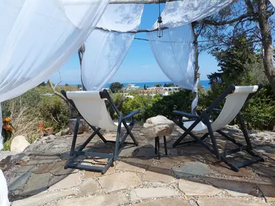two chairs under a tent with a view of the ocean at Ktima Natura in Archangelos
