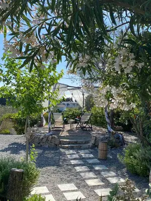 a garden with a table and chairs under a tree at Ktima Natura in Archangelos