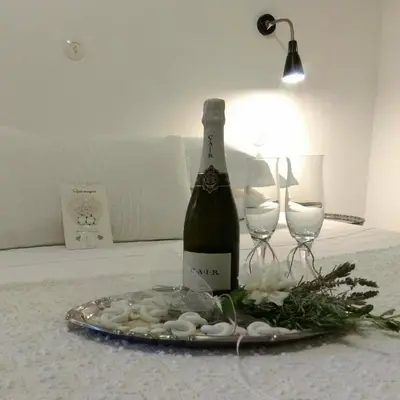 a bottle of wine on a plate with two wine glasses at Ktima Natura in Archangelos