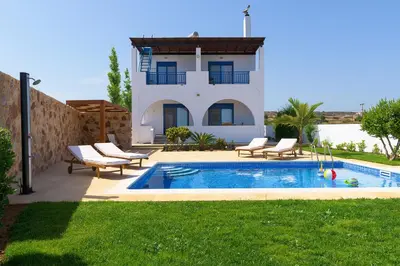 a villa with a swimming pool in front of a house at Villa Deep Blue in Lachania