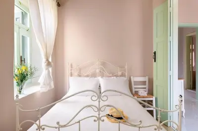 a white bed in a room with a window at Aerino in Symi