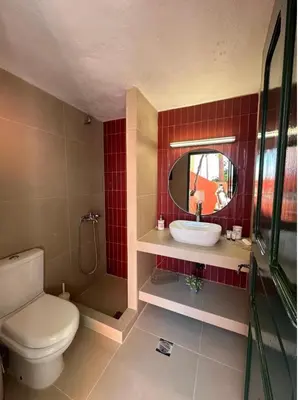a bathroom with a toilet and a sink and a mirror at Aerino in Symi