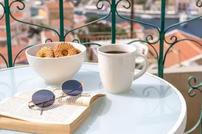 a table with a cup of coffee and a book at Aerino in Symi