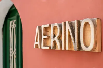 a sign on a red wall with the wordarma at Aerino in Symi