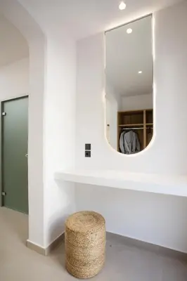 a bathroom with a mirror and a stool at Stay Helios in Faliraki