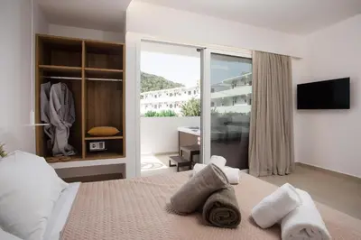 a bedroom with a bed with towels on it at Stay Helios in Faliraki